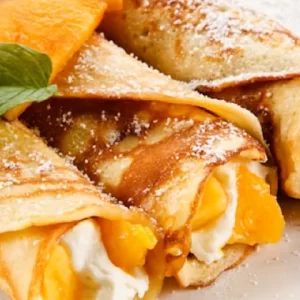 Crêpes fourrées à la crème chantilly saveur fleur d'oranger avec de belles pêches
